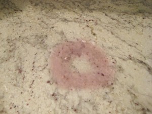 Un bicchiere sporco di vino rosso ha prodotto questa macchia su un piano in granito.